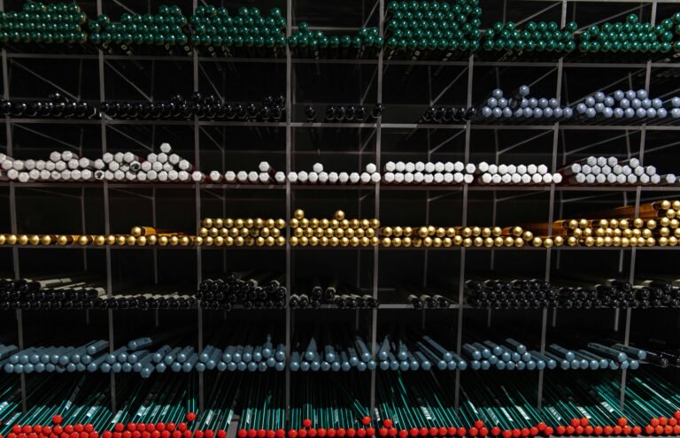 A vibrant assortment of colorful pens organized on shelves for a visually appealing stationery display.