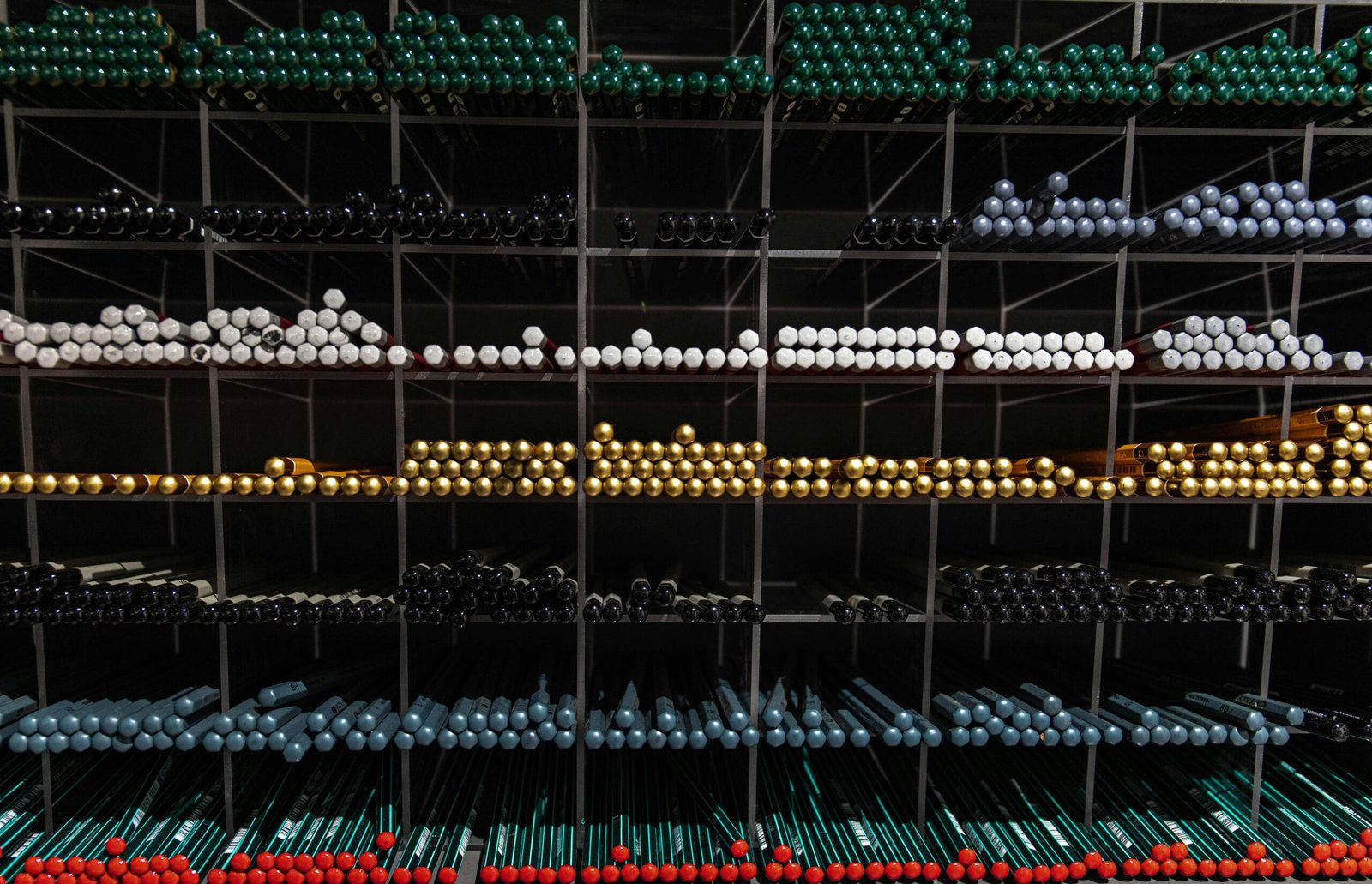 A vibrant assortment of colorful pens organized on shelves for a visually appealing stationery display.